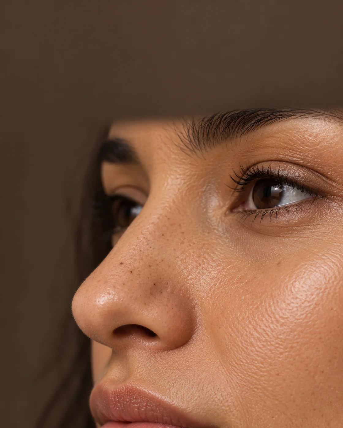 Vue rapprochée d’un nez adulte avec quelques points noirs discrets et une texture cutanée naturelle